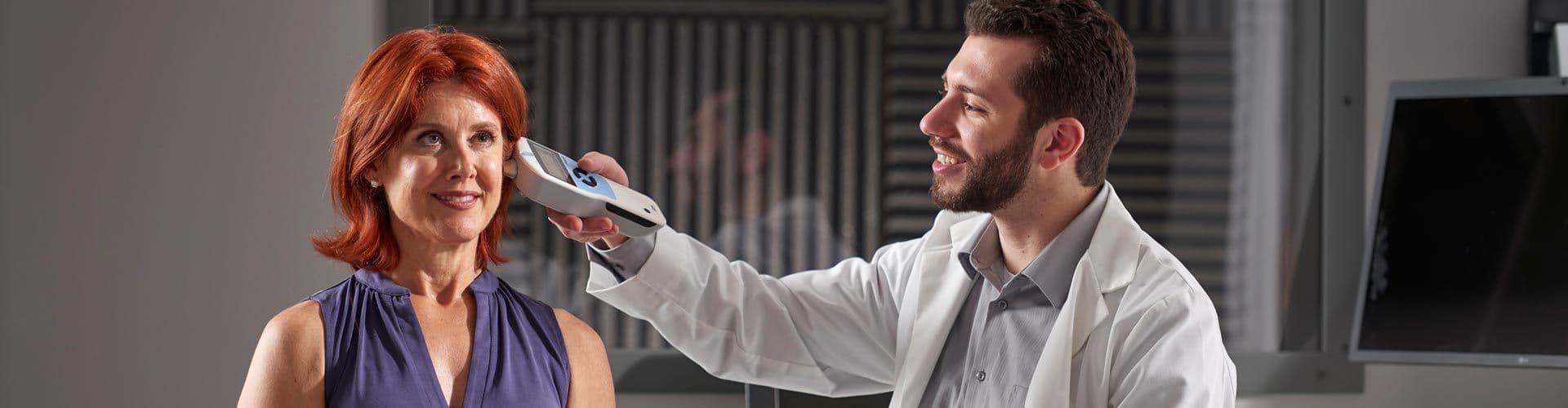 Audiologist performing screening tympanometry on a patient
