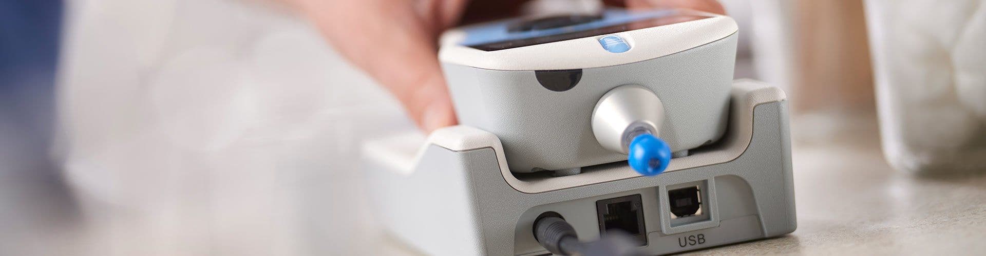 Allegro Tympanometer being placed in the charging cradle